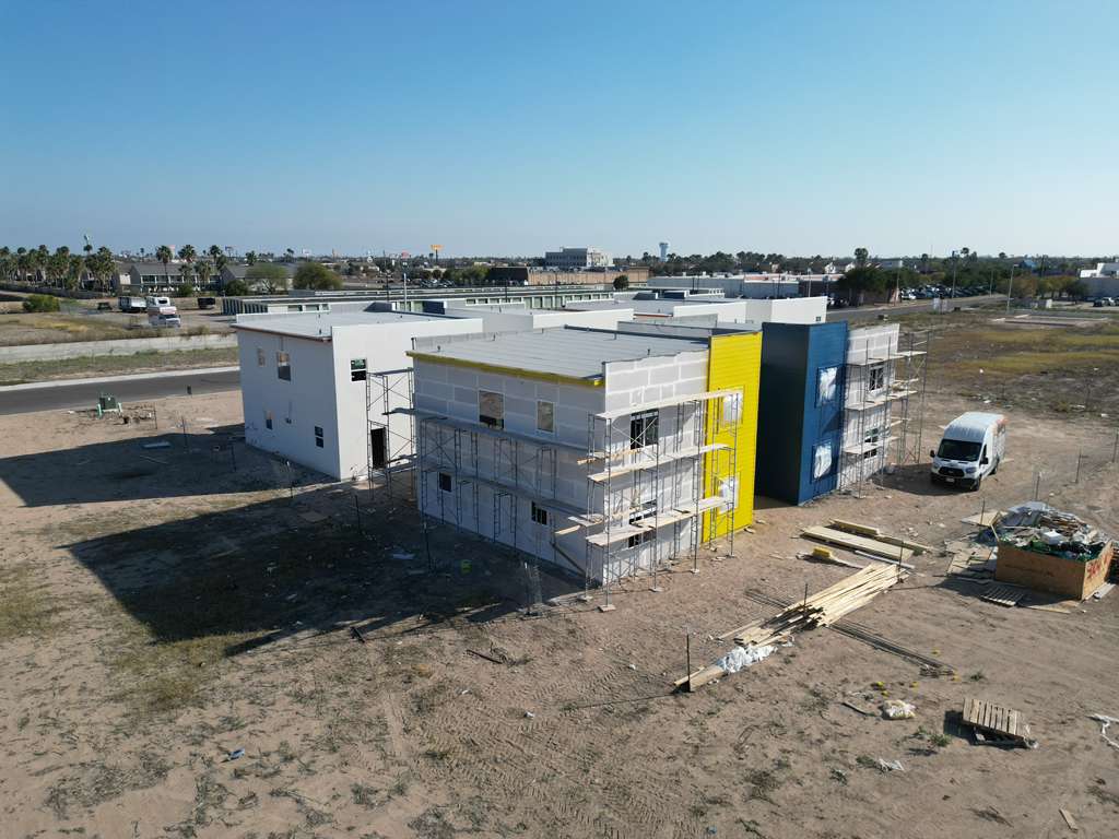 Vista de drone — edificio en obra con colores de marca